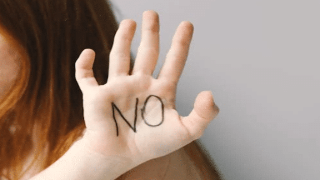 A woman showing her palm with the word “no” on it