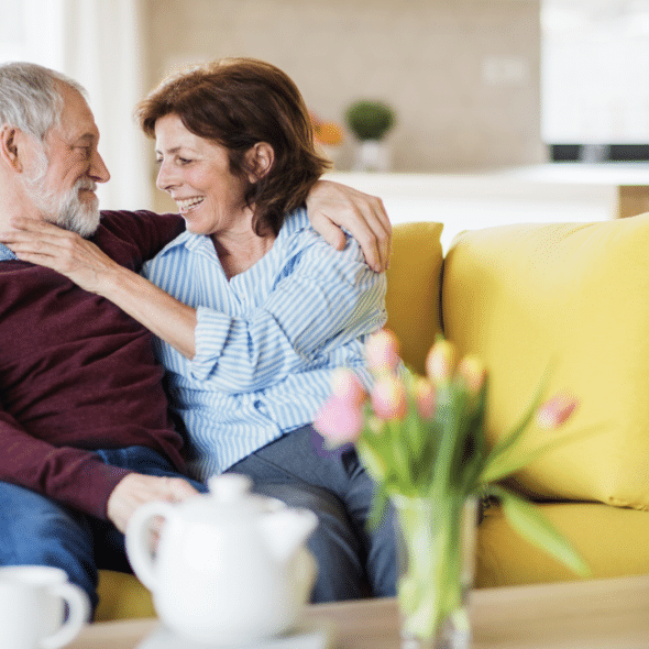 A mature couple cuddling on the couch