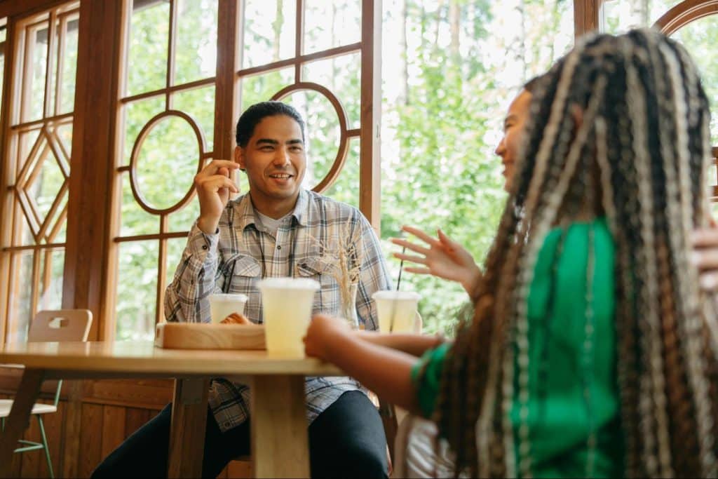 A man smiling while talking to woman