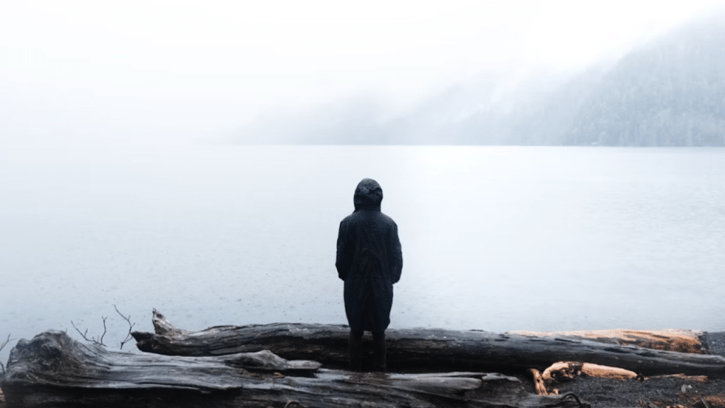 A man looking sad while watching the water