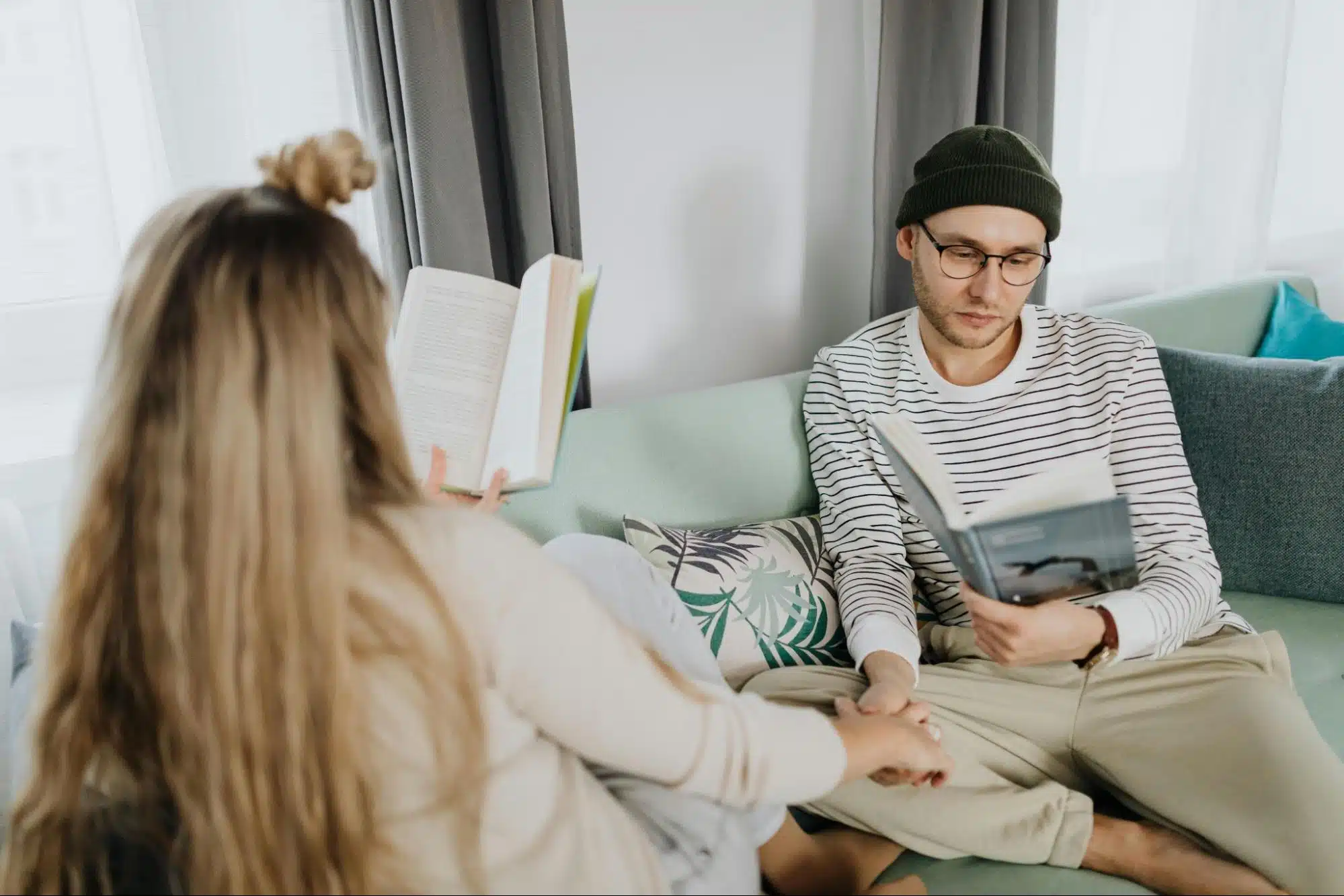 A couple reading a book while holding hands.