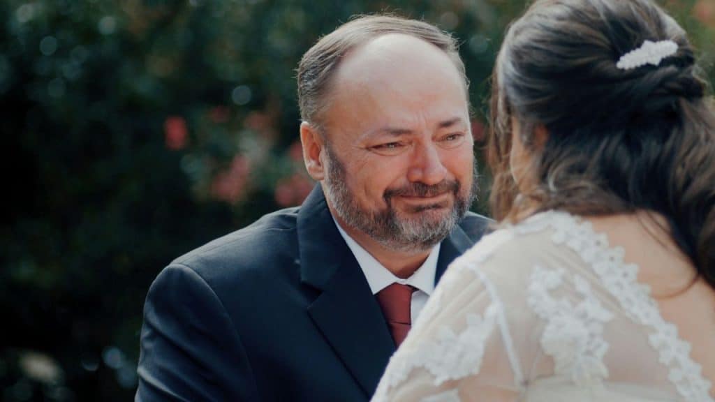 A middle-aged man with tears in his eyes looks at the woman.