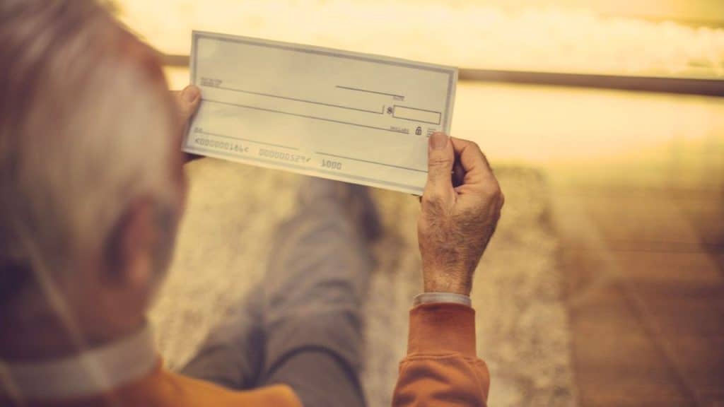 A person's hands holding up an empty check to be filled out.