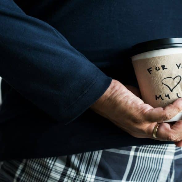 A man surprising his wife with a coffee