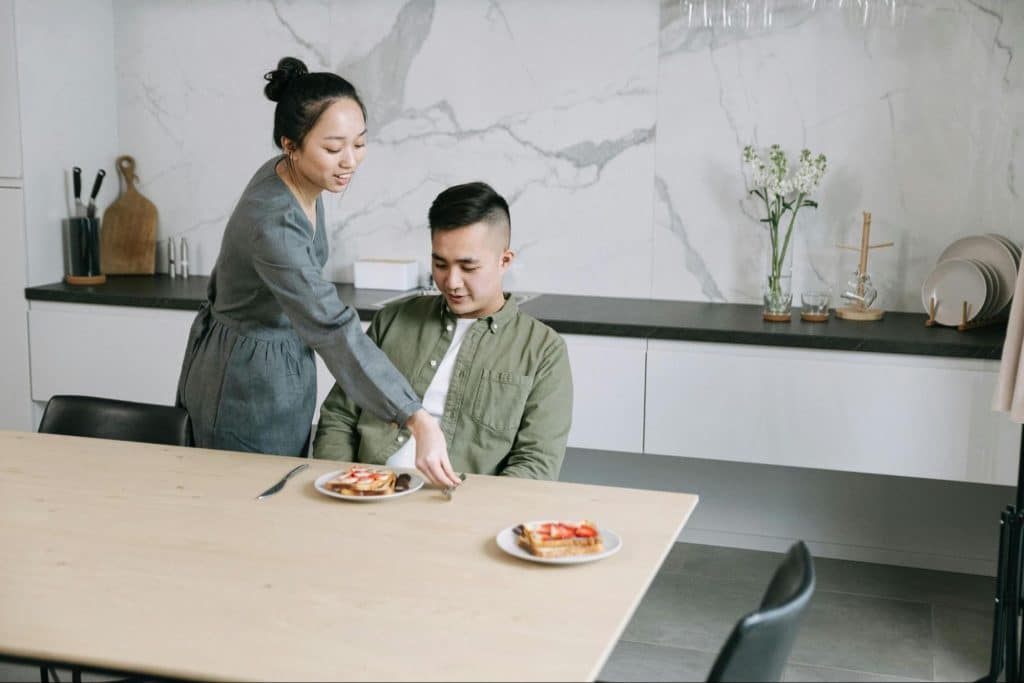 A woman cooking a meal for man