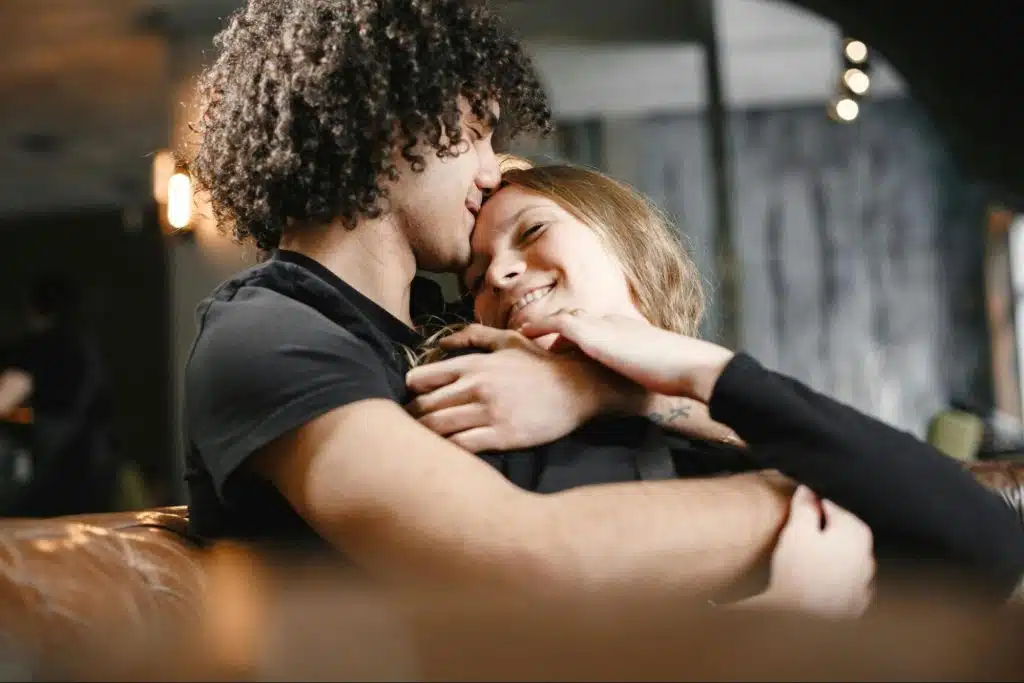 A man kissing a woman’s forehead