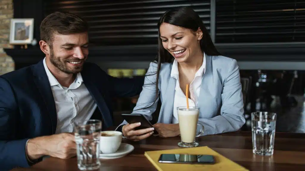 A woman checking her phone while in a restaurant with her husband 