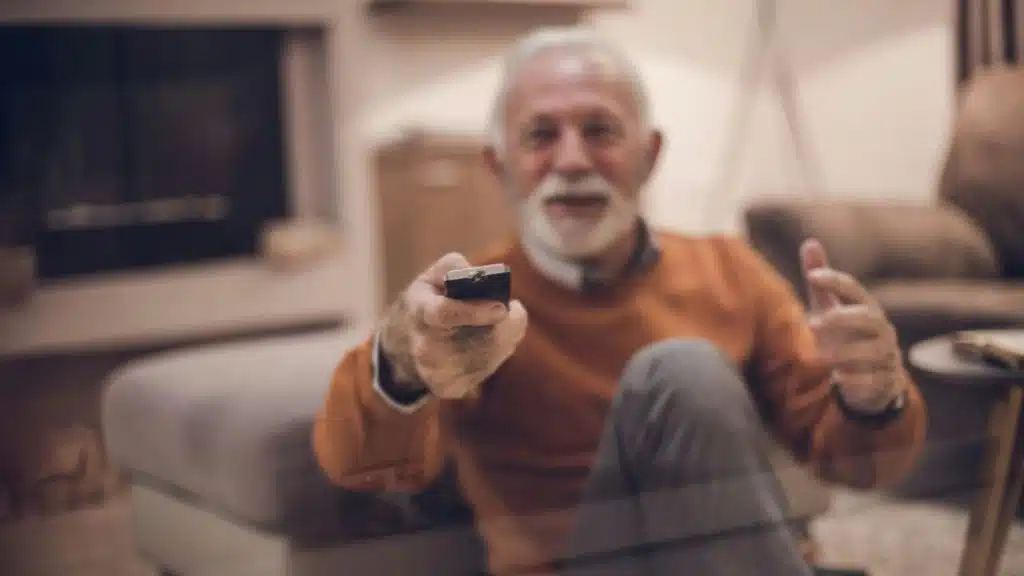 A stylish older man sips coffee while using his phone outdoors.
