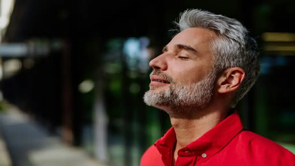 A handsome mature man taking a deep breath