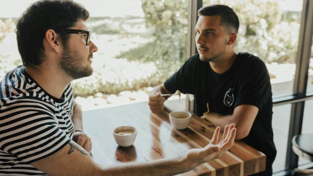 Two men are seated at a table, engrossed in a discussion.