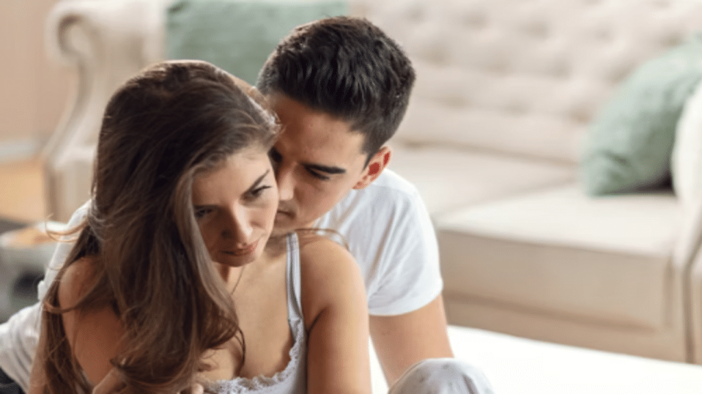 A woman looking sad while her husband hugs her