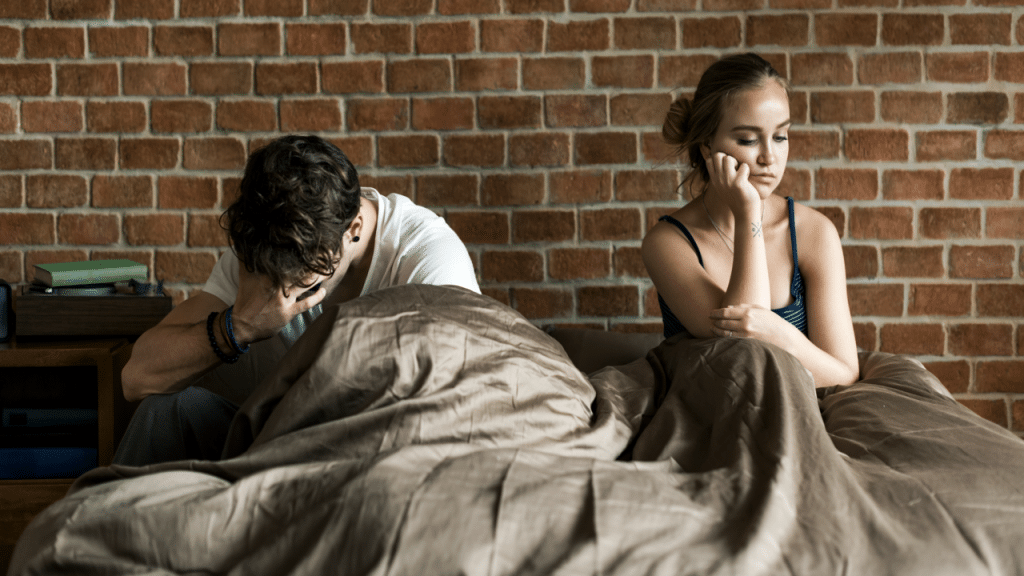 A couple looking sad in the bedroom