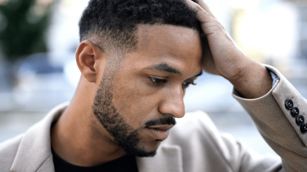 A man looking stressed outdoors