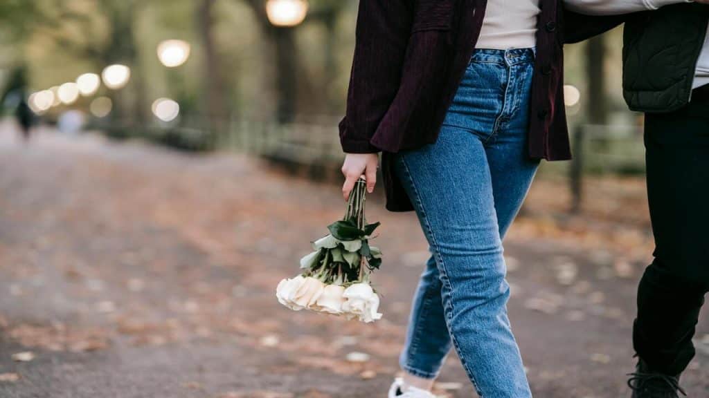 A couple walking with a bouquet of roses