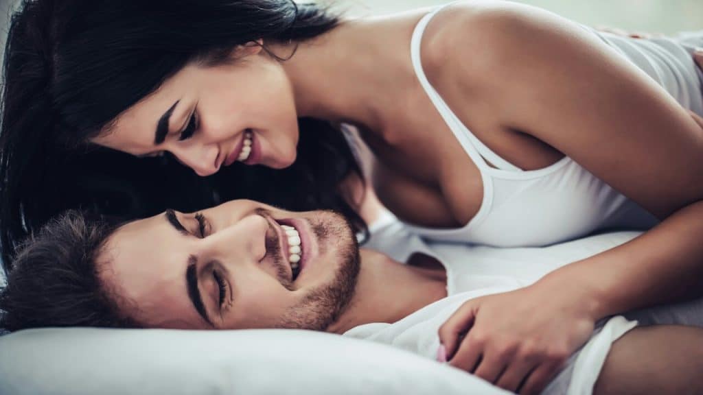 A couple cuddling in bed