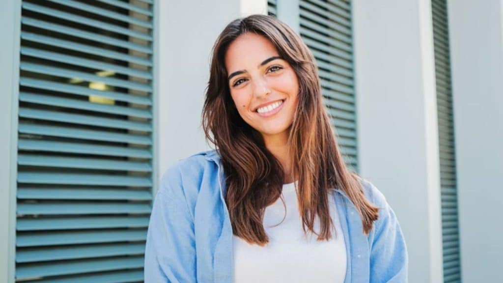 A woman smiling brightly outdoors