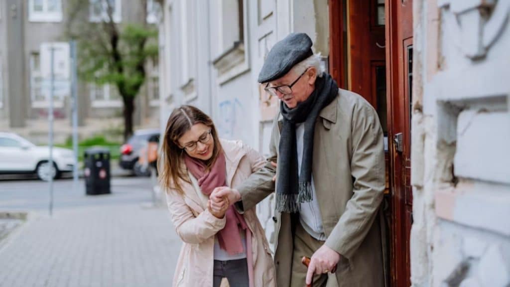 A woman helping an elderly walk