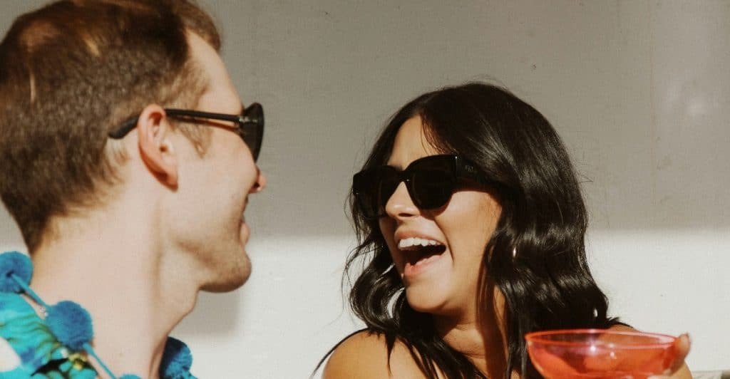 Friends laughing and clinking their glasses together
