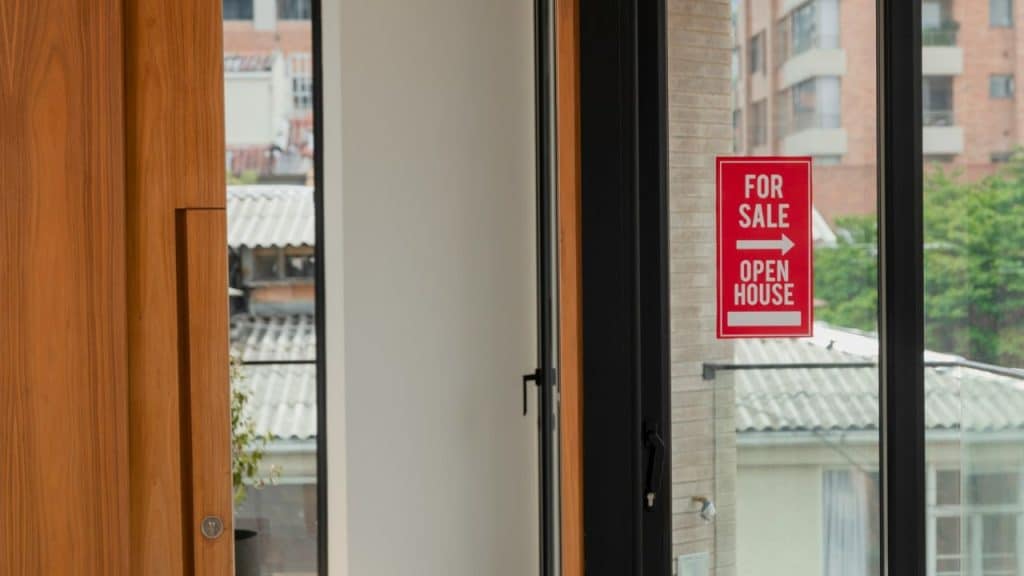 A red and white For Sale and Open House sign is visible on a glass door.