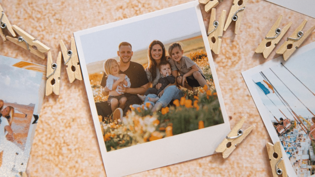 A square photo shows a smiling family of four sitting in a field of orange flowers.