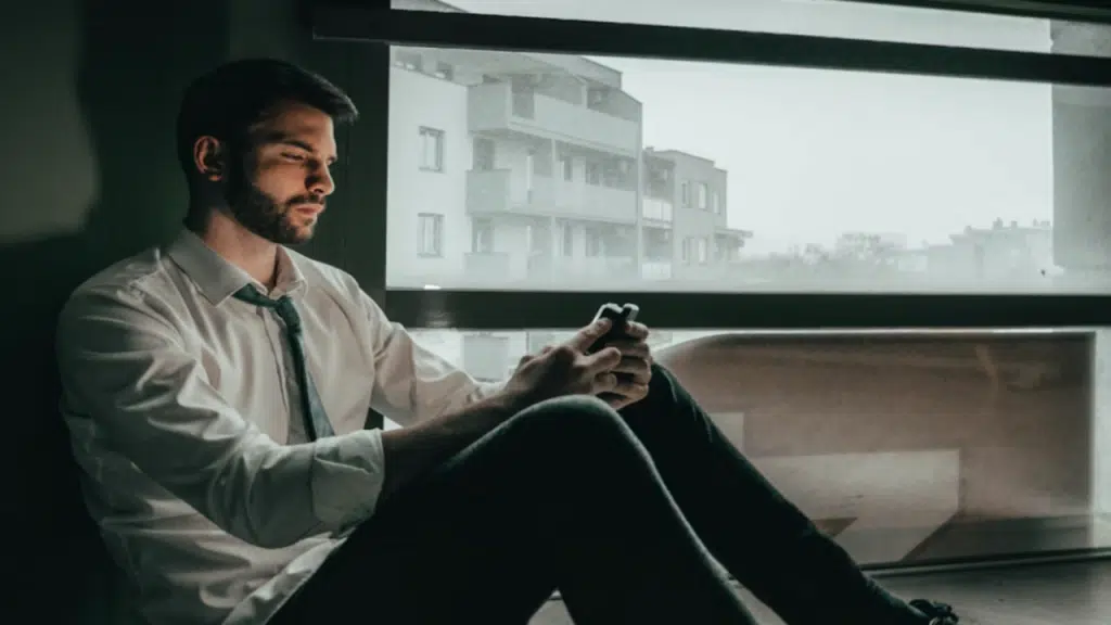 A man looking sad while texting