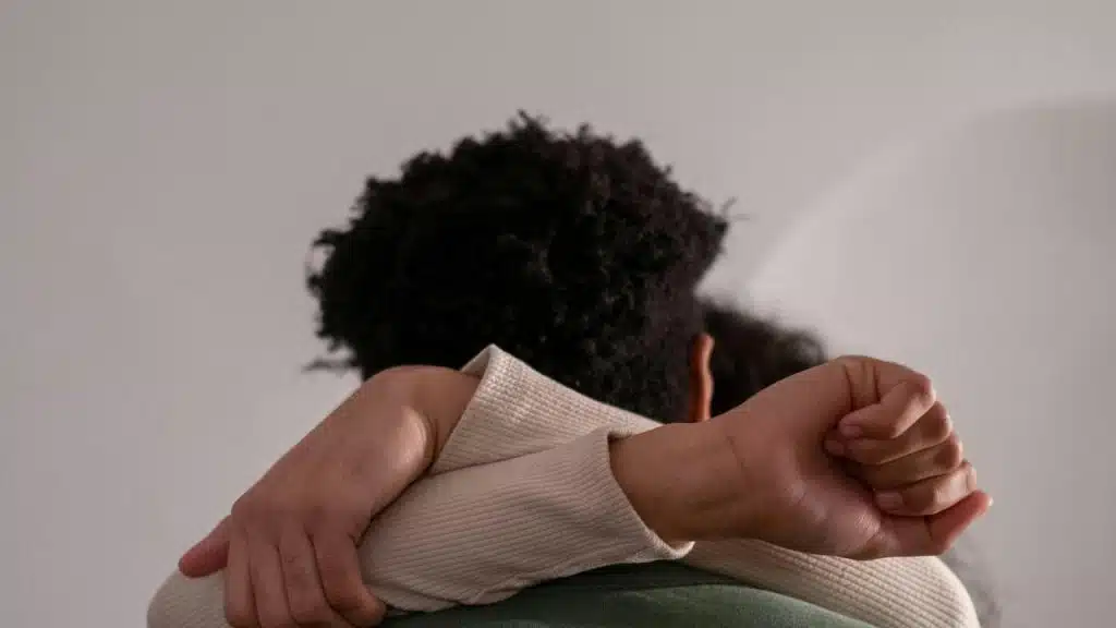 A person hugging another person with their arm resting on the shoulder.