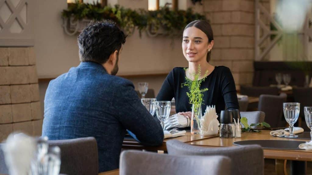 A man and a woman sitting across from each other at a restaurant table.