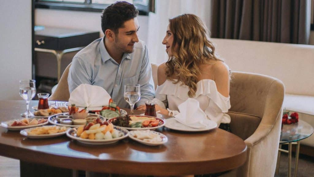 A couple sitting at a table enjoying a meal together.