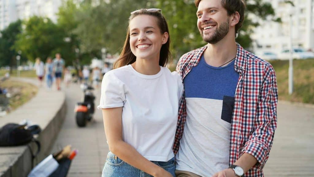 A smiling couple walking together outdoors.