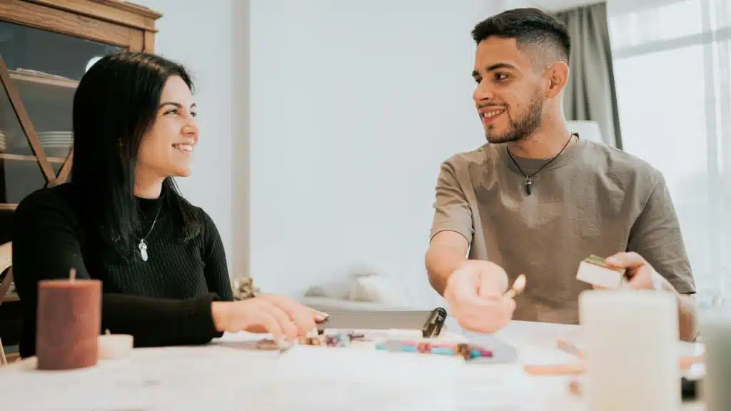 A man and woman smiling while playing a tabletop game together.