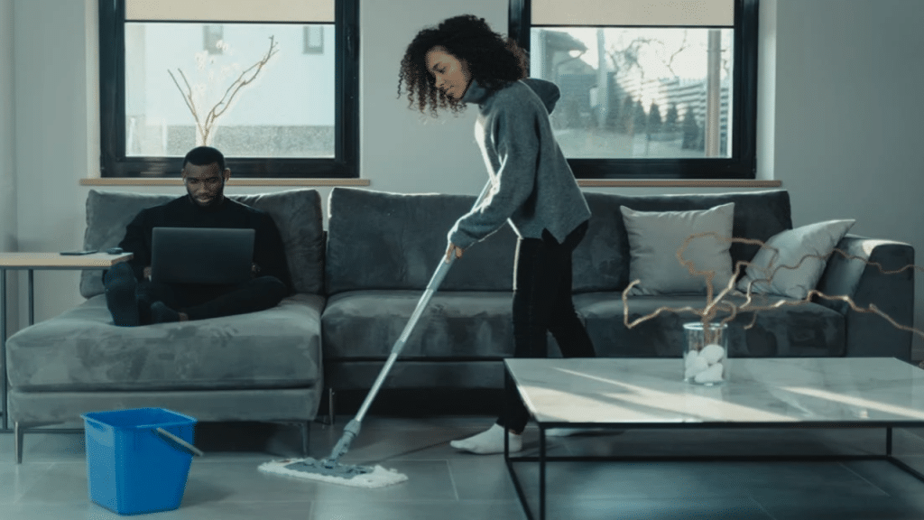 A man works while his wife cleans
