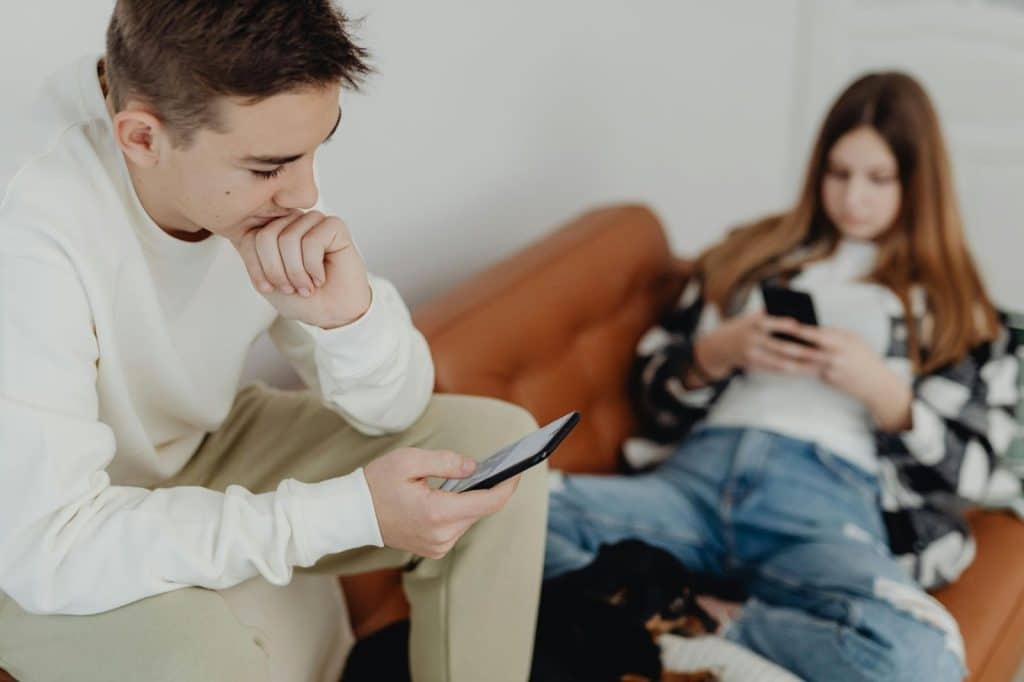 A man and woman looking at their phones