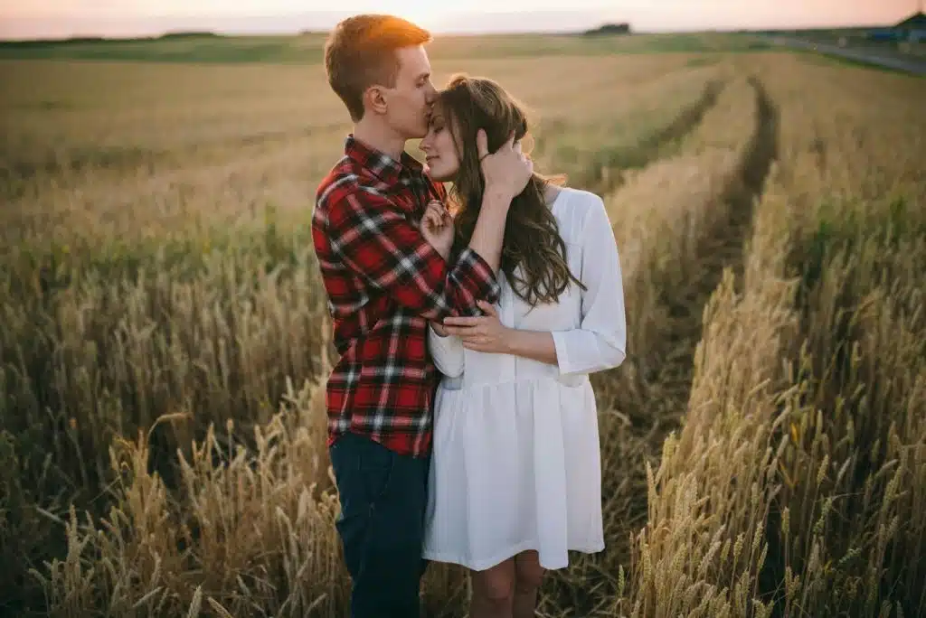 A man kissing a woman’s forehead