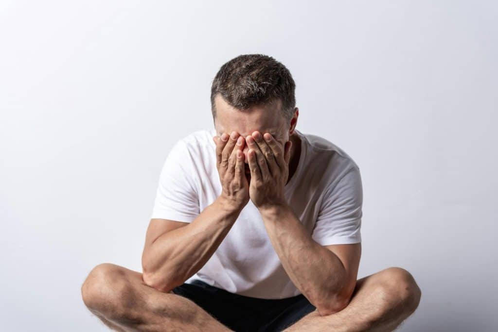 A man covering his face