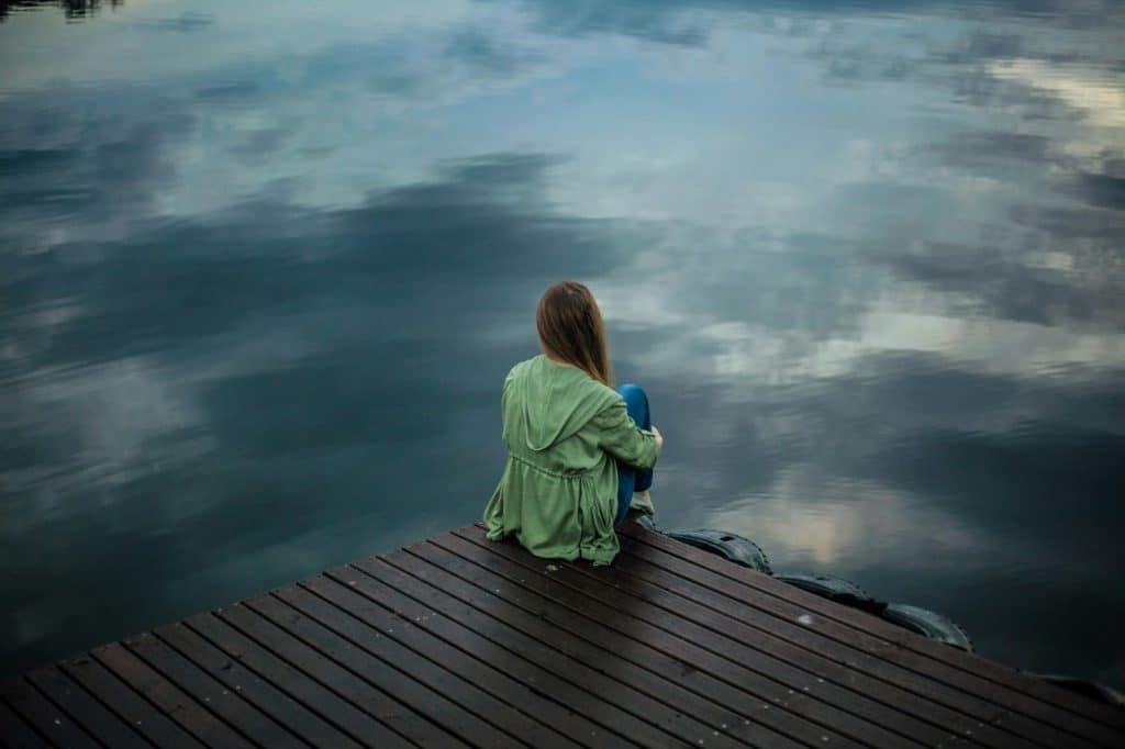 A woman sitting at the wooden plank