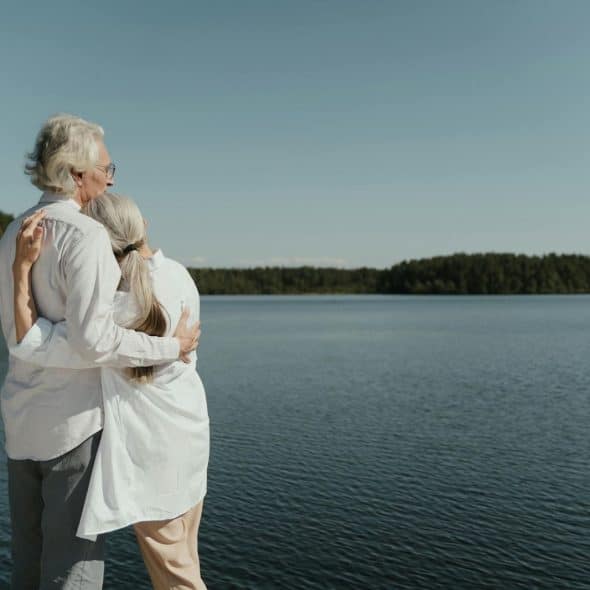 A man and woman looking at the lake