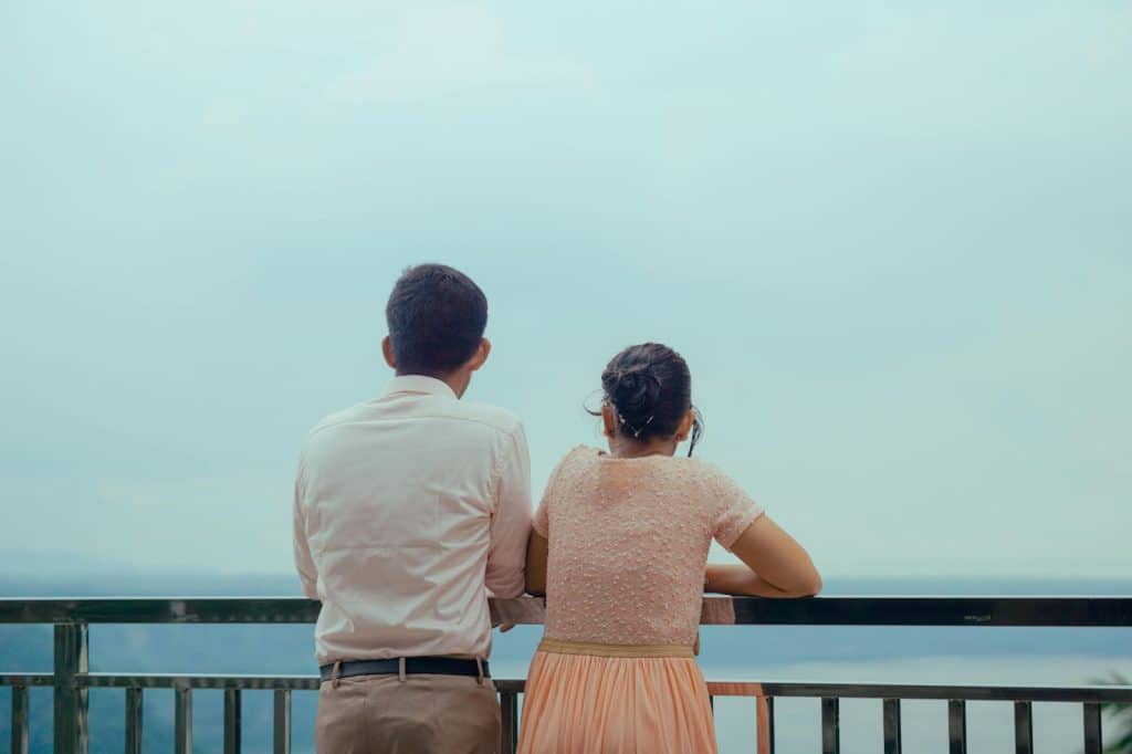 A man and woman looking at the balcony