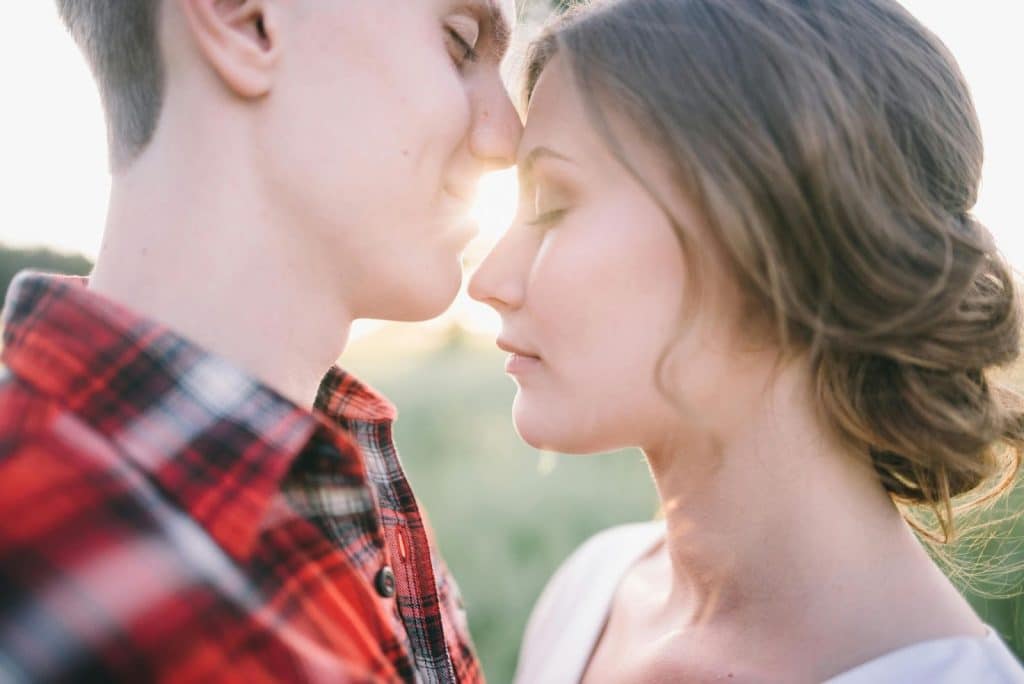 A man kissing a woman’s head