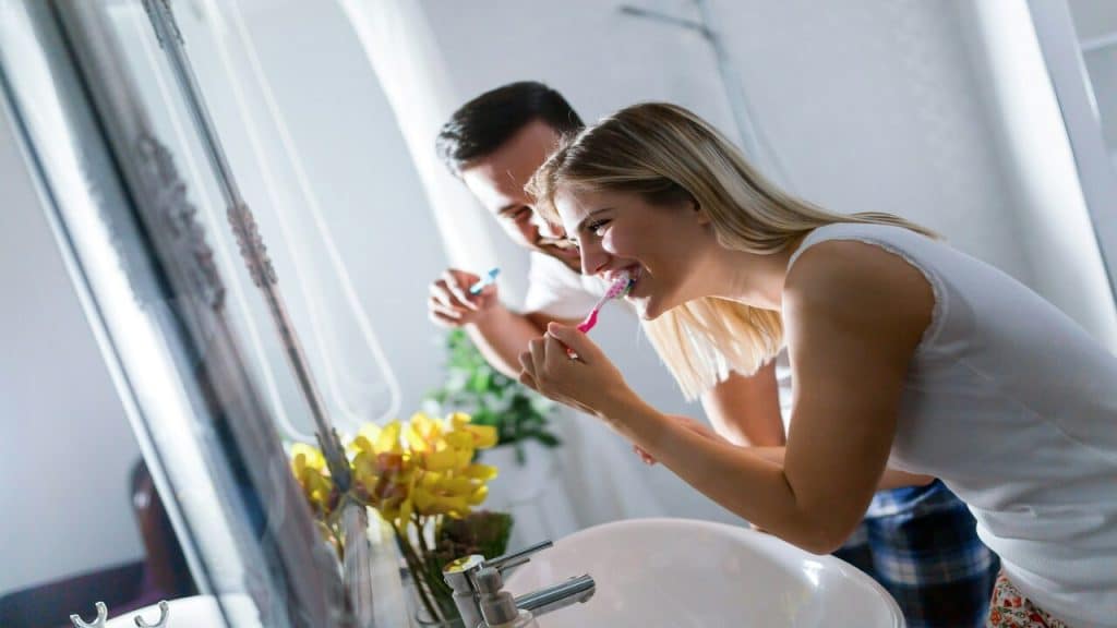 A couple brushing their teeth together