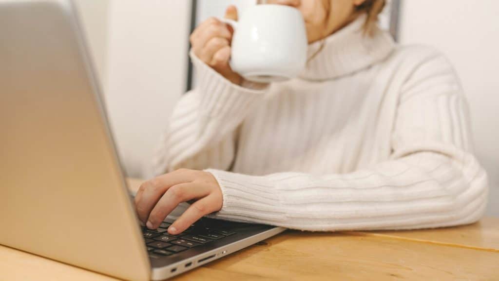 A woman drinking coffee while working