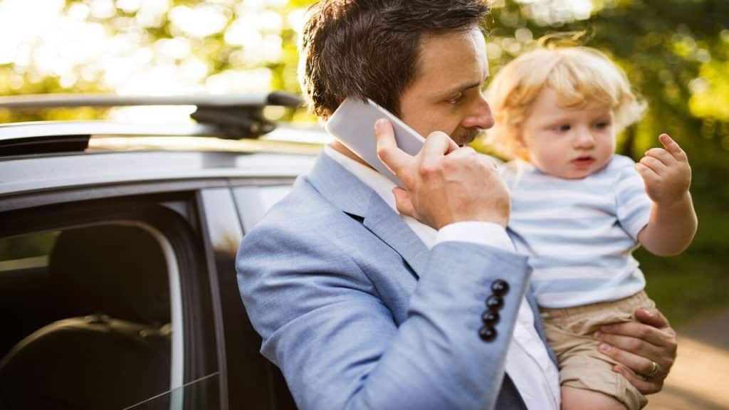 A dad on the phone while carrying his baby