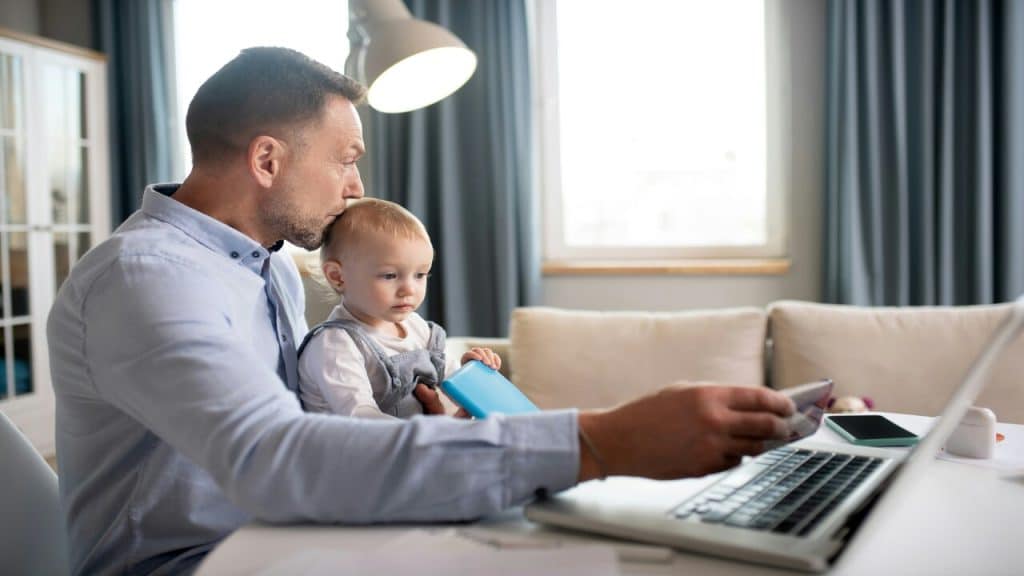 A man working while taking care of his baby