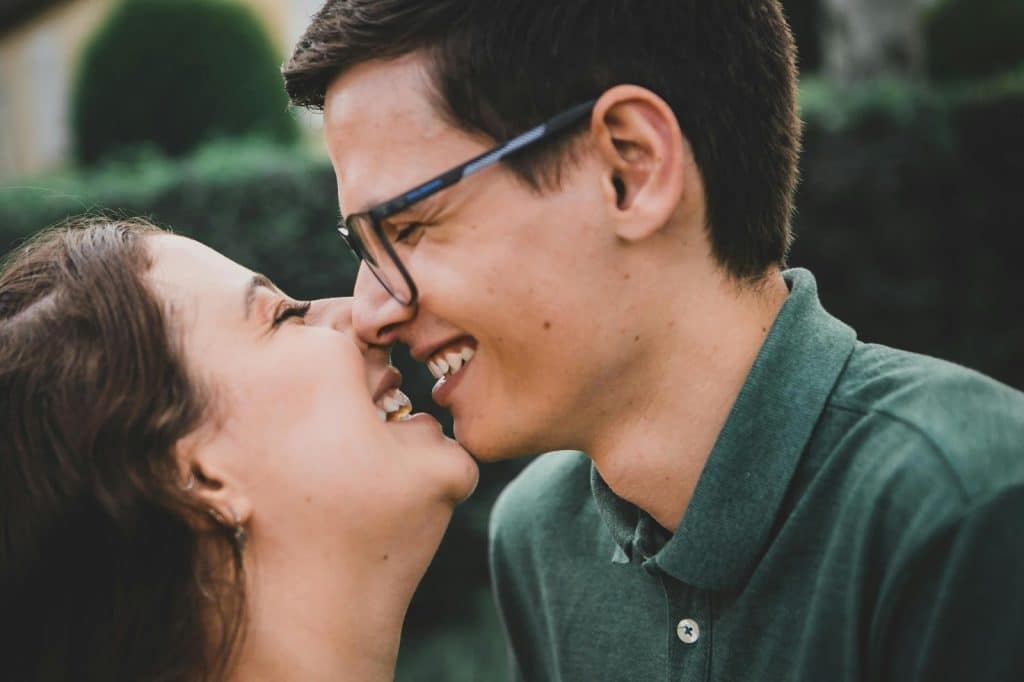 A man and woman laughing while kissing