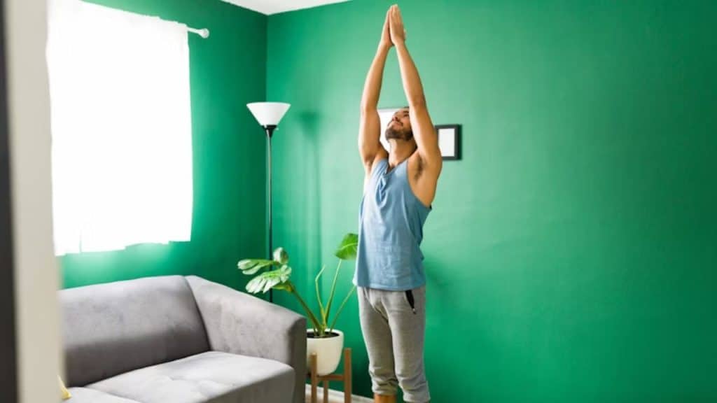 Man doing yoga at home in the living room