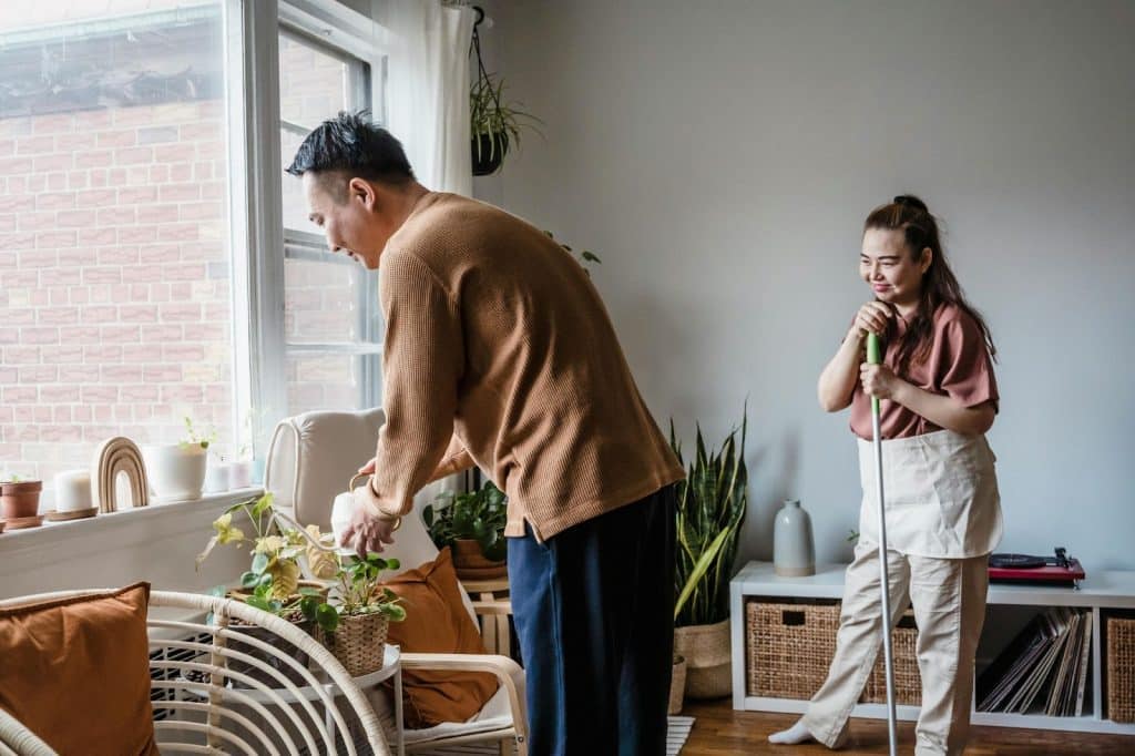 A man taking care of a plant for a woman