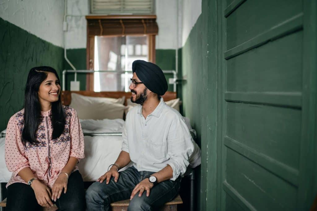 A man and woman sitting at the bed