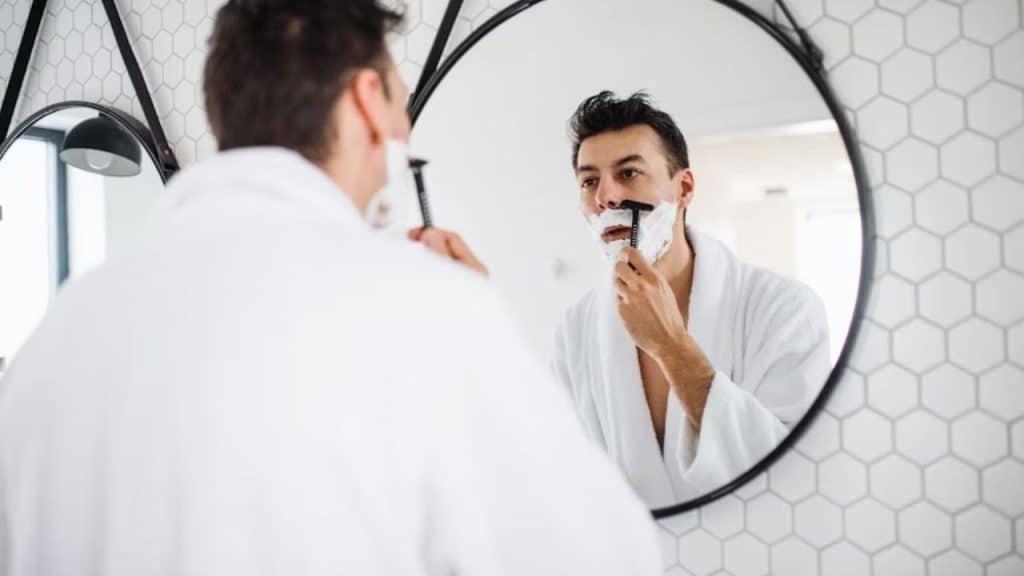 Man grooming in front of a mirror
