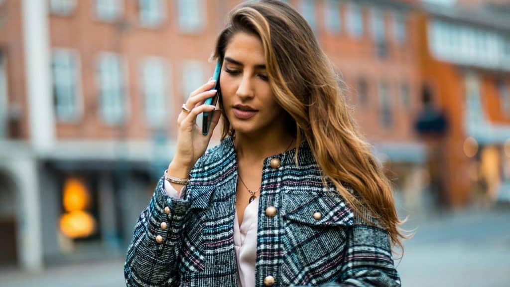 A woman talking on her phone while walking outdoors.