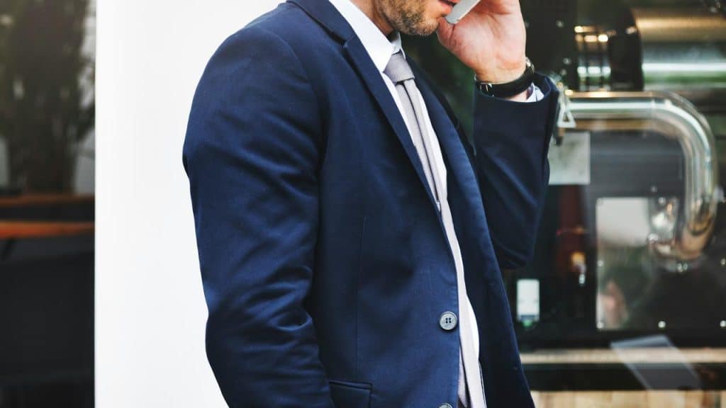 A man in a suit talking on a smartphone.