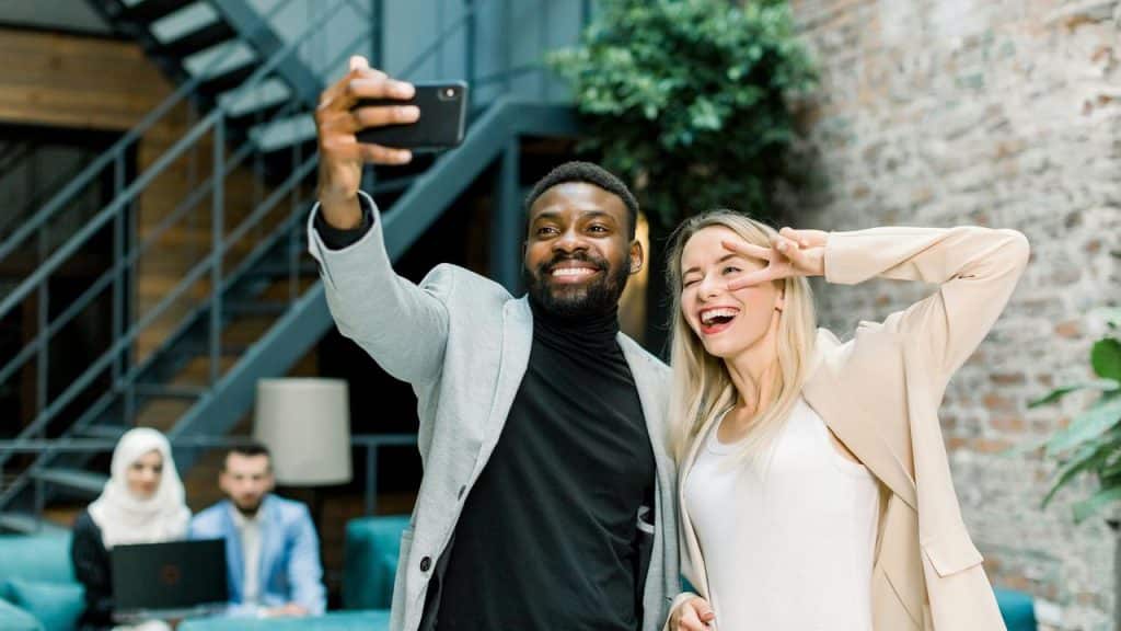 A smiling man and woman taking a selfie together indoors.